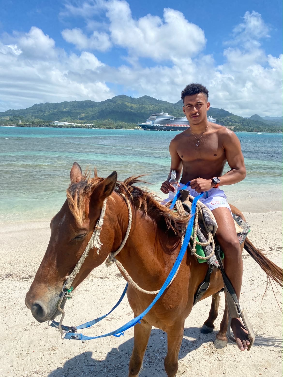 John E. riding a horse on a beach